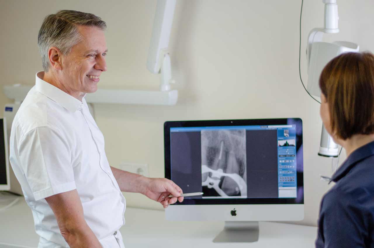 Dr. Huhn erklärt Patientin ein Röntgenbild.